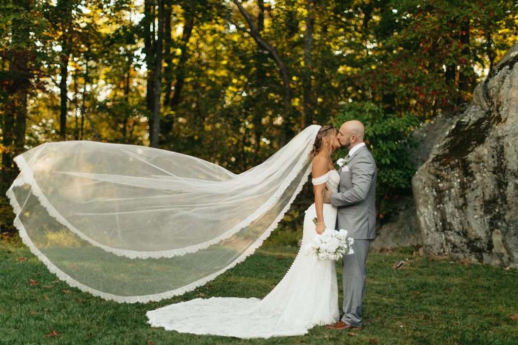 Bridal couple kssing in front of rock.